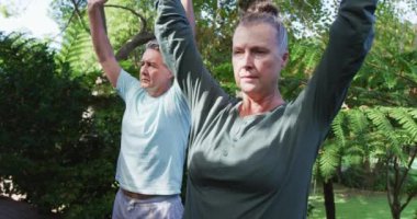 Rahat Kafkasyalı çift bahçede birlikte yoga yaparken mutlu oluyor. sağlıklı emeklilik yaşam tarzı.