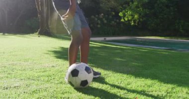 Afrikalı Amerikalı baba ve oğlunun bahçede futbol oynadığı orta bölüm. Babalık ve aşk kavramı