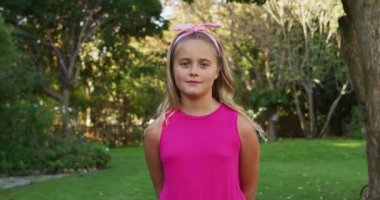 Bahçede kameraya gülümseyen mutlu beyaz kız portresi. evde boş zaman geçirmek.