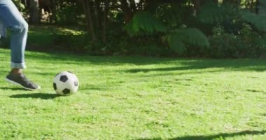 Afrikalı Amerikalı baba ve oğlunun bahçede futbol oynadığı orta bölüm. Babalık ve aşk kavramı