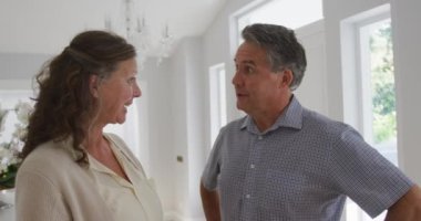 Oturma odasında gülümseyen mutlu beyaz bir çiftin portresi. emeklilik yaşam tarzı evde.