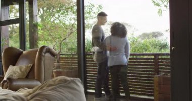 Mutlu çift kucaklaşıp konuşuyor, balkonda dikilip kırsal manzaranın tadını çıkarıyorlar. boş zamanlarımızı evde geçiriyoruz..