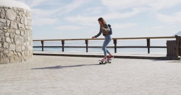 快乐的混血女子在阳光灿烂的海滨长廊上滑板 健康的生活 远离网格 接近自然 — 图库视频影像