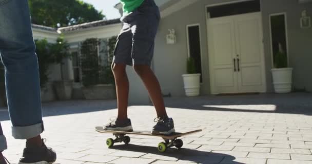Afro Amerikaanse Vader Leert Zijn Zoon Skateboarden Voortuin Vaderschap Liefde — Stockvideo