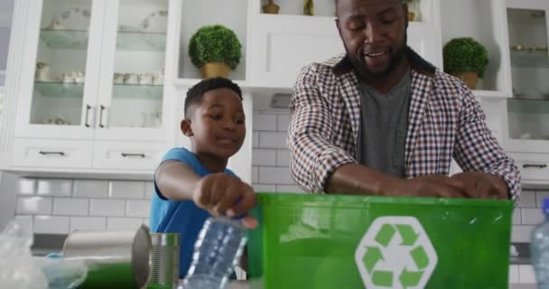 Szczęśliwy Afrykański Ojciec Syn Stojący Kuchni Wkładający Plastikowe Śmieci Pudełka — Wideo stockowe