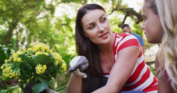 Mère Fille Caucasiennes Souriantes Jardinant Parlant Tenant Des Fleurs Jaunes — Video