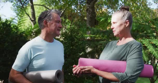 Feliz Pareja Caucásica Mayor Hablando Sonriendo Sosteniendo Colchonetas Yoga Jardín — Vídeos de Stock