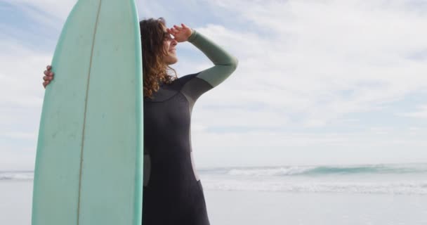 Güneşli Sahilde Elinde Sörf Tahtasıyla Dikilmiş Gülümseyen Mutlu Bir Melez — Stok video