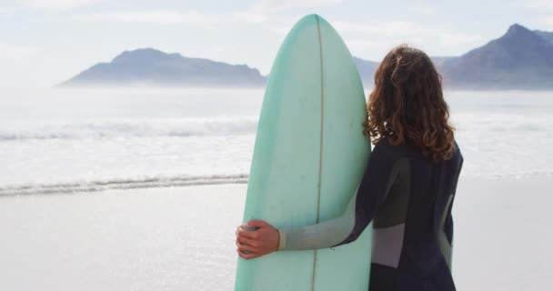 Vista Trasera Una Mujer Raza Mixta Parada Playa Sosteniendo Una — Vídeos de Stock