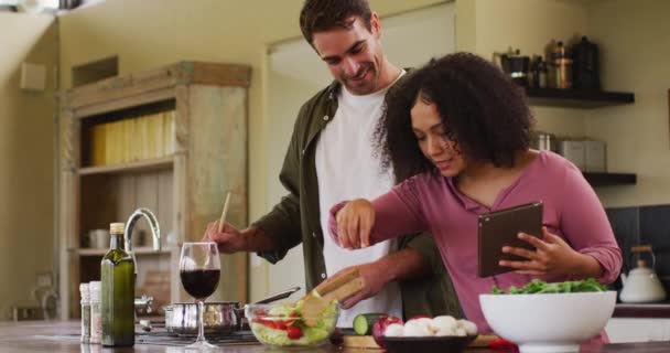 Happy Diverse Couple Preparing Meal Together Kitchen Using Recipe Tablet — Video