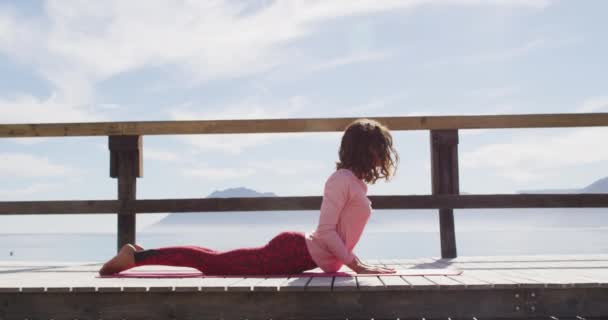 Femme Mixte Saine Pratiquant Yoga Extérieur Couché Étirant Par Mer — Video