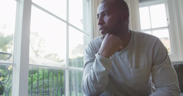 Stressed African American Man Looking Out Window While Sitting Couch — Stock Video