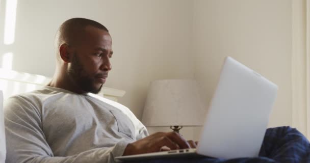 Αφροαμερικάνος Που Χρησιμοποιεί Φορητό Υπολογιστή Ενώ Κάθεται Στο Κρεβάτι Στο — Αρχείο Βίντεο