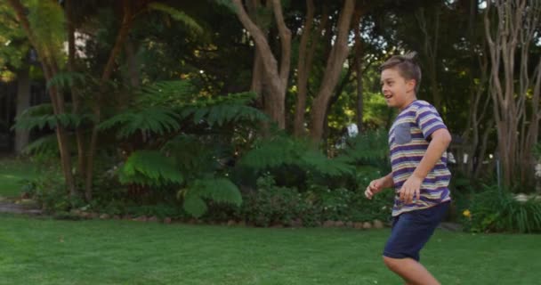 庭で父の腕の中に走って飛び込む幸せな白人の息子 幸せな家族は家で自由時間を過ごし — ストック動画