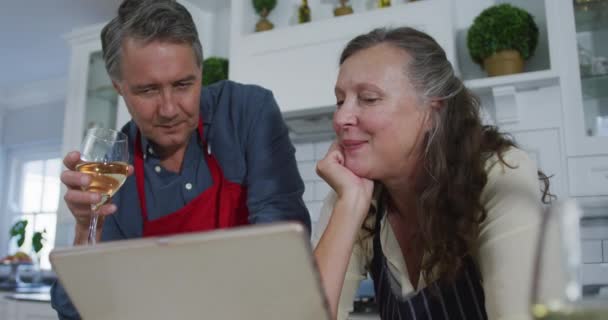 Feliz Pareja Ancianos Caucásicos Cocina Mirando Computadora Portátil Hablando Disfrutando — Vídeo de stock