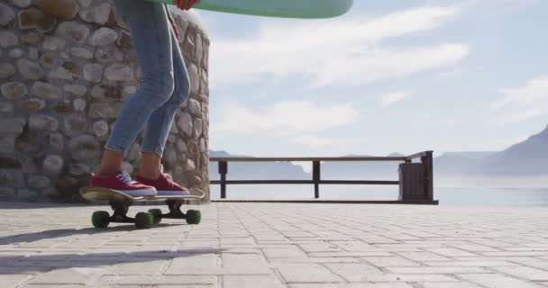 Gelukkig Gemengd Ras Vrouw Skateboarden Dragen Surfplank Zonnige Promenade Aan — Stockvideo