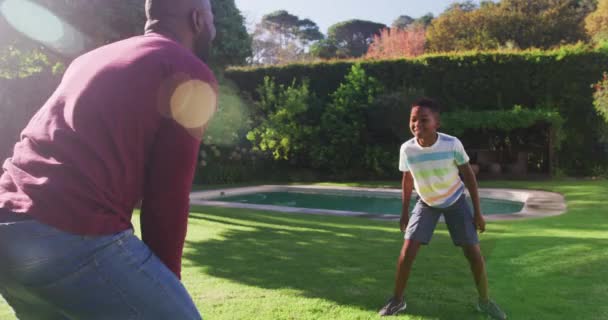在阳光灿烂的日子里 非裔美国人的父亲和儿子一起在花园里踢足球 父爱概念 — 图库视频影像