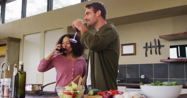 Happy Diverse Couple Preparing Meal Together Kitchen Drinking Wine Embracing — ストック動画