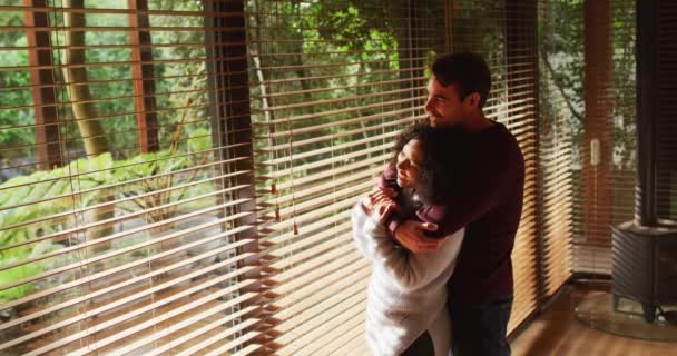 Feliz Pareja Diversa Abrazando Sonriendo Sala Estar Mirando Por Ventana — Vídeos de Stock