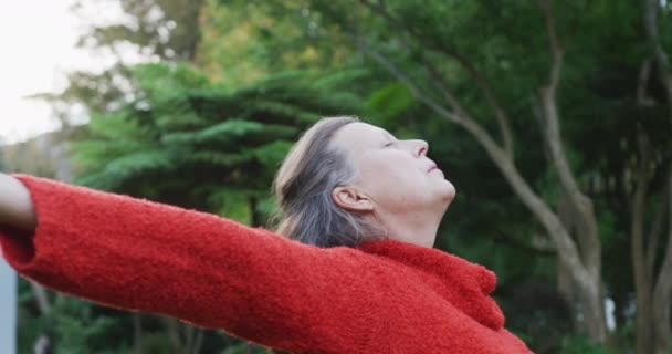 庭に立つ幸せなシニア白人女性は 目を閉じてリラックスして立っている 家庭での健康的な退職生活だけで — ストック動画