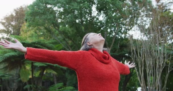庭に立つ幸せなシニア白人女性は 目を閉じてリラックスして立っている 家庭での健康的な退職生活だけで — ストック動画