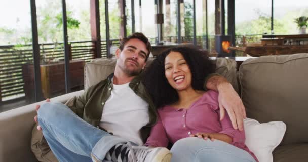 Happy Diverse Couple Sitting Couch Living Room Watching Embracing Smiling — ストック動画