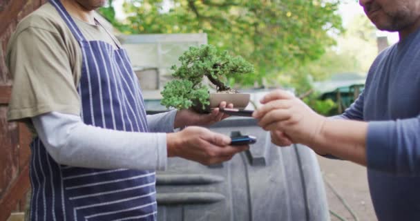Vit Manlig Trädgårdsmästare Som Säljer Växter Med Kontaktlösa Betalningar Trädgårdscentret — Stockvideo