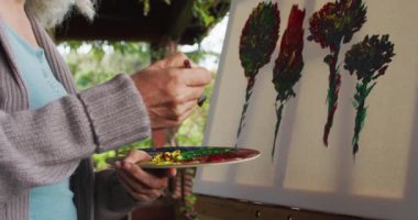 Balkonda resim yapan son sınıf melez kadın. emeklilik ve yaşlılık hayatı, evde yalnız zaman geçirmek..