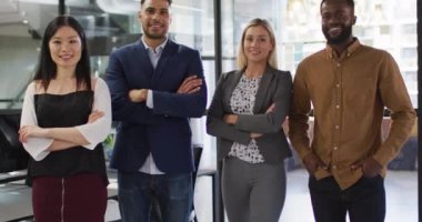 Kameraya bakarak kollarını kavuşturup gülümseyen çeşitli iş adamlarının portresi. Bağımsız bir yaratıcı şirkette çalışmak.