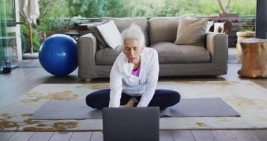 Son sınıf melez kadın yoga yapıyor, meditasyon yapıyor. emeklilik ve yaşlılık hayatı, evde yalnız zaman geçirmek..