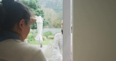 Yetişkin kızını kucaklayan mutlu Asyalı anne arka kapıya geliyor. Mutlu aile birlikte evde iyi vakit geçiriyor..