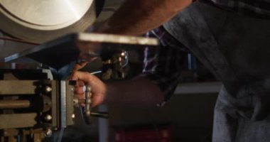 Testereyle atölyedeki beyaz erkek bıçak imalatçısı. Bağımsız küçük işletmeci iş başında.