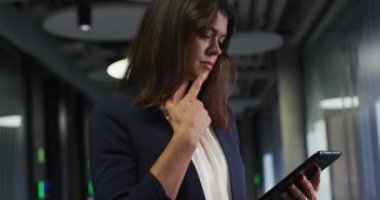 Kafkasyalı iş kadını, kahverengi saçlı, modern ofiste tablet kullanıyor. İş ve iş adamları ofis kavramında.