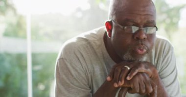 Düşünceli Afro-Amerikan son sınıf öğrencisinin, bastona yaslanmış portresi. Emeklilik hayatı, evde yalnız zaman geçirmek..