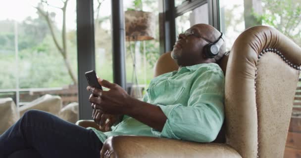 Happy Afro Amerikaanse Senior Man Ontspannen Fauteuil Luisteren Met Behulp — Stockvideo