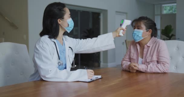 Asian Female Nurse Wearing Face Mask Taking Temperature Female Patient — Stock Video