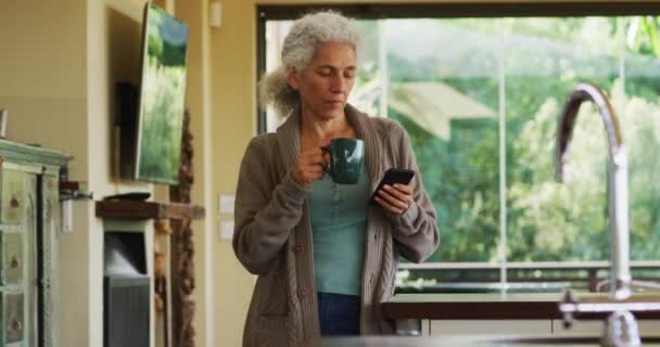 Porträt Einer Seniorin Die Kaffee Trinkt Und Ihr Smartphone Der — Stockvideo