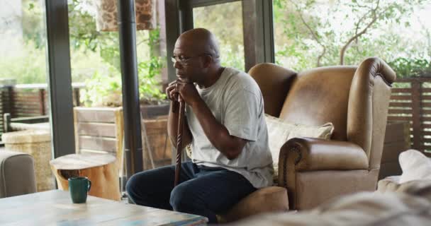 Προνοητικός Αφροαμερικάνος Πρεσβύτερος Που Κάθεται Στο Σαλόνι Ακουμπώντας Στο Μπαστούνι — Αρχείο Βίντεο