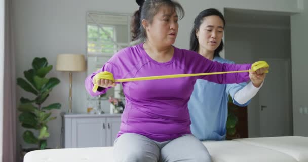 Asiatisk Kvinnlig Sjukgymnast Som Hjälper Kvinnliga Patienter Att Träna Armar — Stockvideo