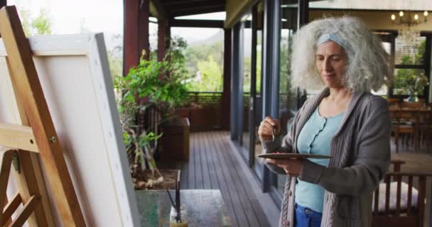 阳台上的高级混血女子绘画 退休和老年生活方式 独自呆在家里 — 图库视频影像