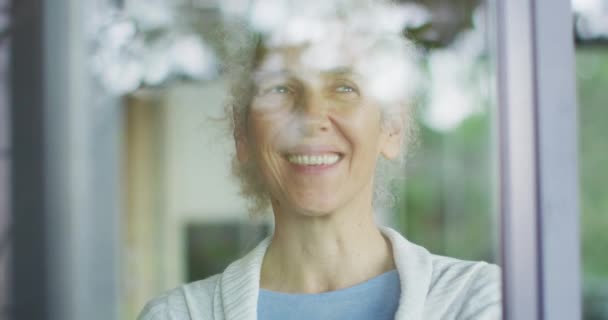 Starsza Mieszanka Rasowa Wyglądająca Przez Okno Uśmiechnięta Emerytura Starszy Styl — Wideo stockowe