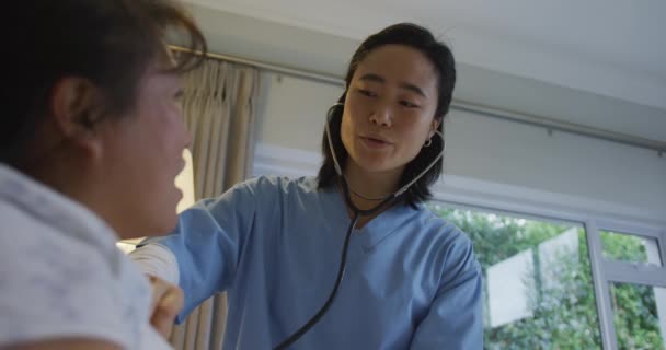 Steteskop Kullanan Gülümseyen Asyalı Kadın Doktor Hastanede Yatan Kadın Hastayı — Stok video