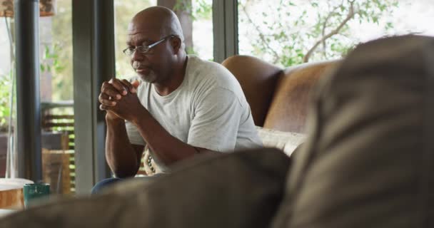 富有远见的非洲裔美国老人头枕着头坐在扶手椅上 退休生活方式 独自呆在家里 — 图库视频影像