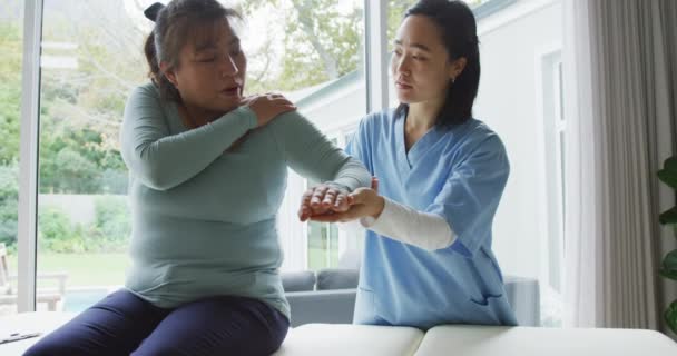 Asian Female Physiotherapist Treating Female Patient Surgery Moving Her Arm — Stock Video