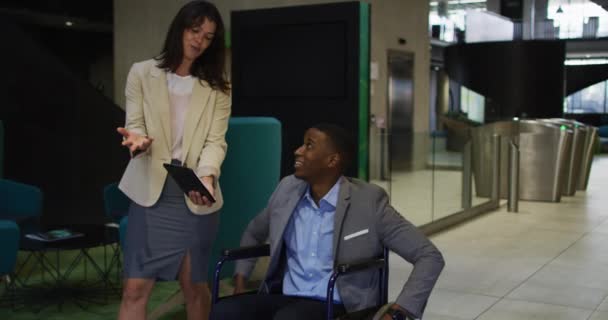 白人の実業家と障害者アフリカ系アメリカ人のビジネスマンは タブレットを使用して車椅子 オフィスコンセプトのビジネス界やビジネス界では — ストック動画