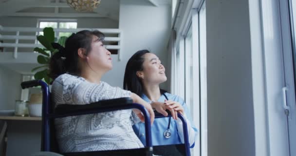 Lächelnde Asiatische Ärztin Die Aus Dem Fenster Schaut Und Mit — Stockvideo