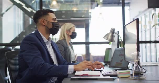 Mieszany Biznesmen Rasy Noszący Maskę Twarzy Korzystający Komputera Kolegą Pracującym — Wideo stockowe