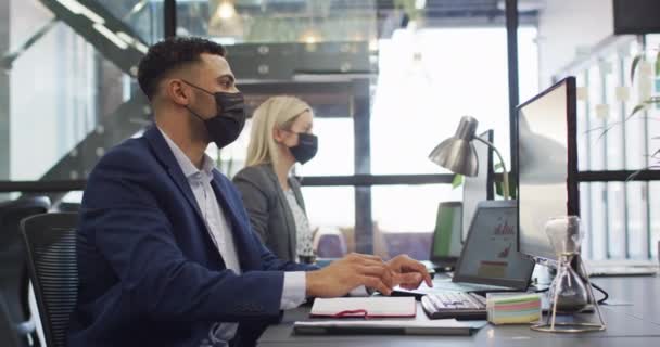 Blandad Ras Affärsman Bär Ansiktsmask Och Använda Dator Med Kollega — Stockvideo