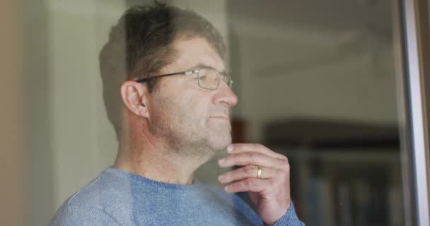 Homem Caucasiano Cuidadoso Usando Óculos Olhando Pela Janela Casa Conceito — Vídeo de Stock