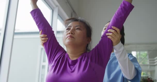 Asiatisk Kvinnlig Sjukgymnast Som Hjälper Kvinnliga Patienter Att Träna Armar — Stockvideo